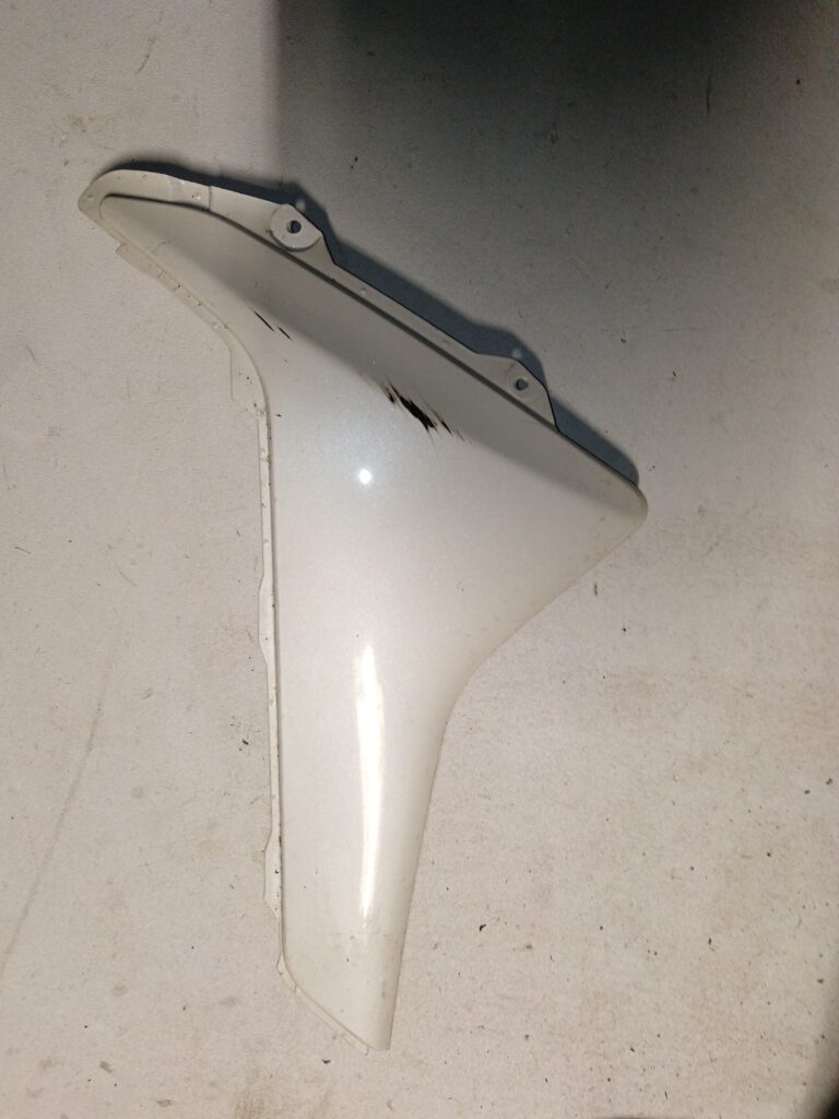 Tapa lateral izquierda original blanca para Yamaha NMAX, vista exterior con acabado brillante.