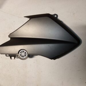 Tapa lateral izquierda negra original para Yamaha XMAX 125, vista exterior con emblema de la marca.
