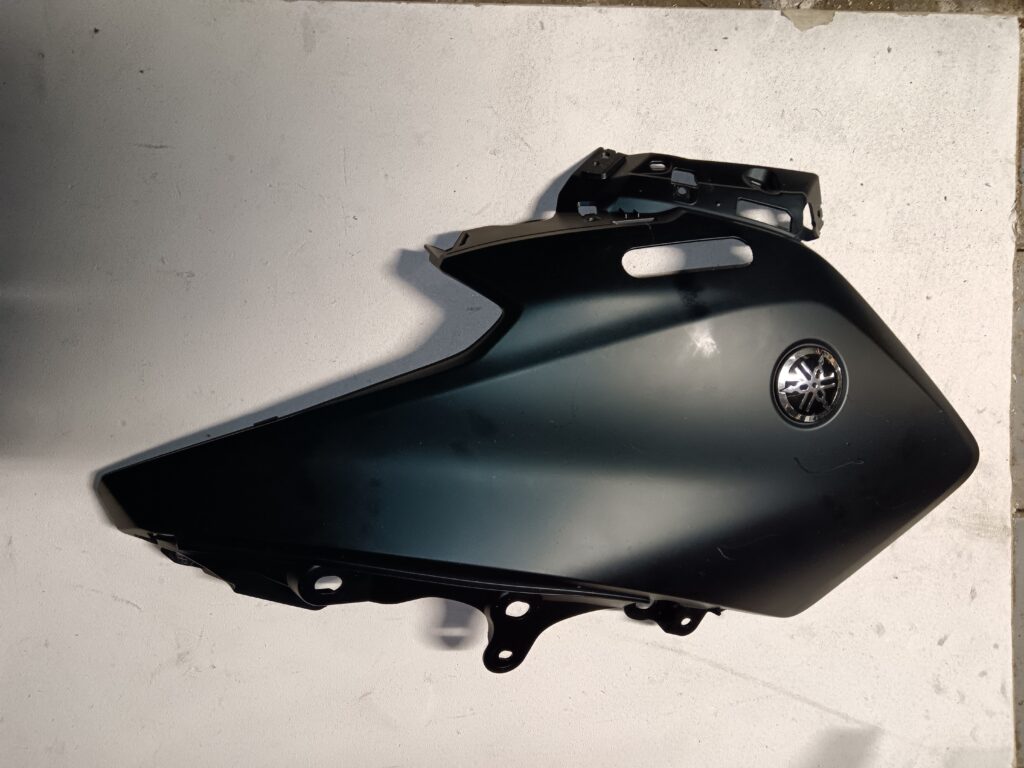 Tapa lateral izquierda negra para Yamaha XMAX 125, compatible con modelos de los años 2010-2013. Recambio original de calidad.