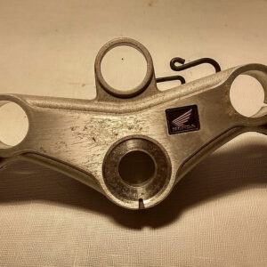 Vista superior de la tija de dirección original en aluminio pulido con emblema de resina para horquilla de Honda CBR 125 R años 2004 a 2006.