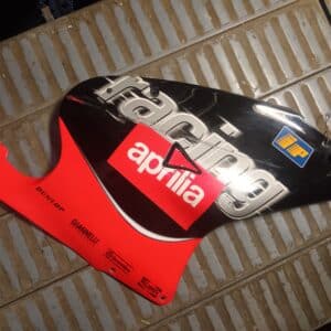 Carenado lateral derecho original para moto Aprilia RS 50 o RS 125, color negro y rojo con logotipos de competición Racing.