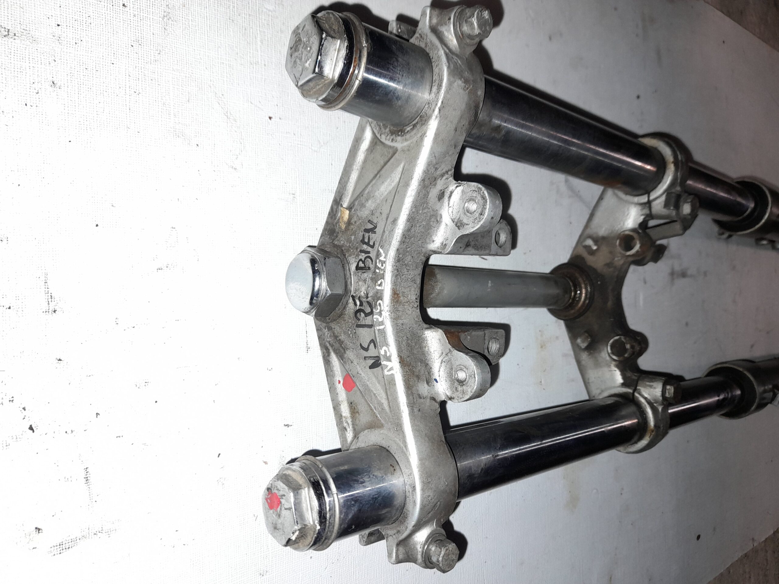 Detalle de la tija y barras de horquilla delantera de Honda NS 125, mostrando el estado de conservación del componente.