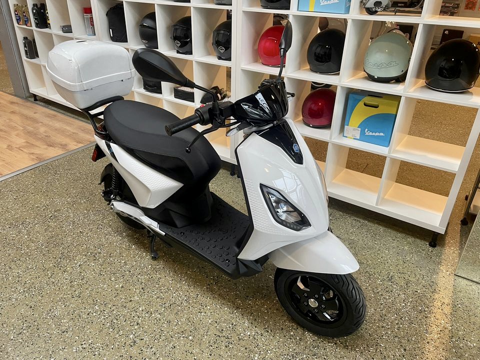 Scooter eléctrico Piaggio 1 Active de color blanco expuesto en tienda.