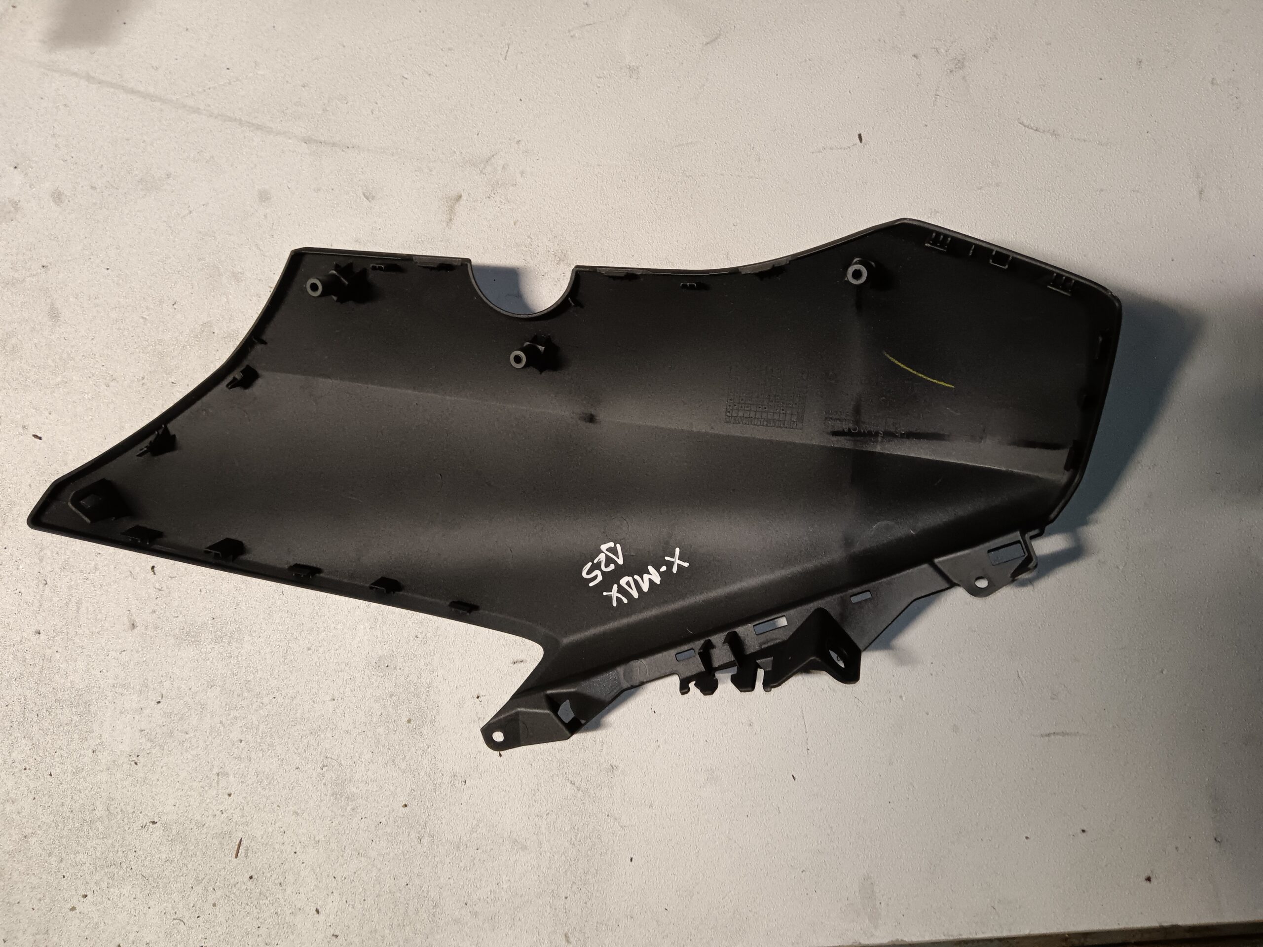 Vista interior de la tapa lateral derecha para Yamaha XMAX 125, mostrando los puntos de anclaje originales y su estado.