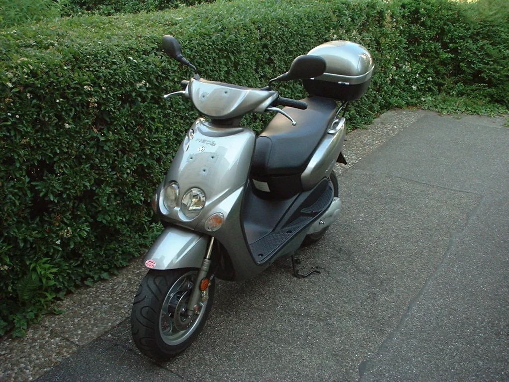 Scooter Yamaha Neos aparcado, un vehículo eficiente para la movilidad urbana diaria que ayuda a reducir el estrés.